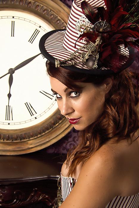 attractive girl in a hat on the background of a clock