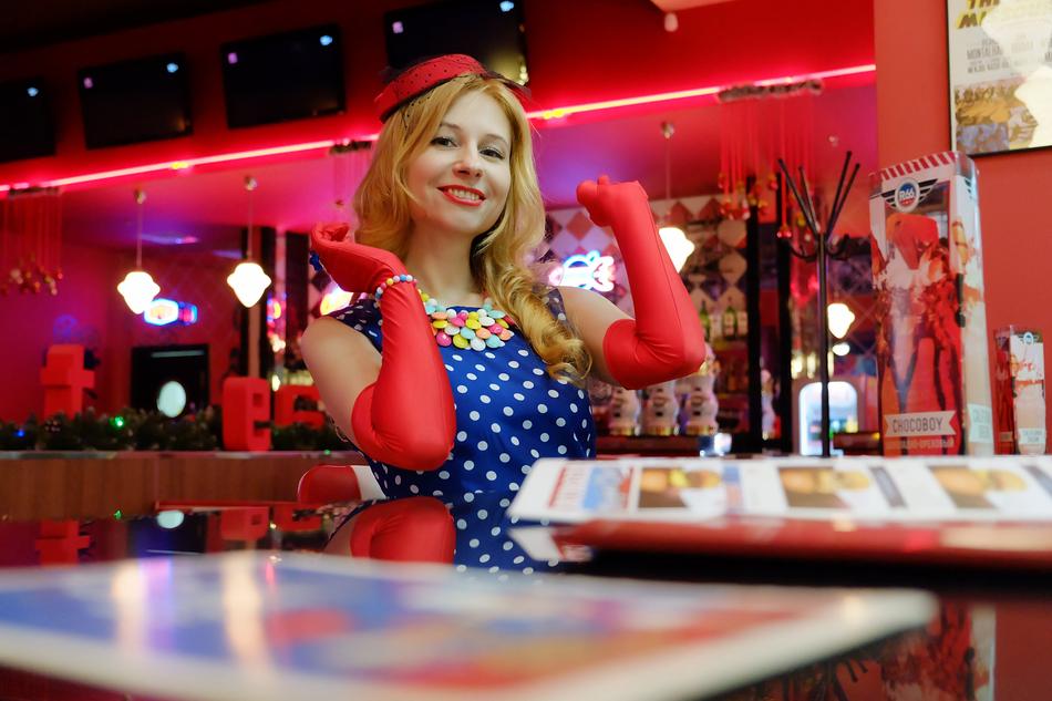 charming girl in 1950s clothes in a cafe
