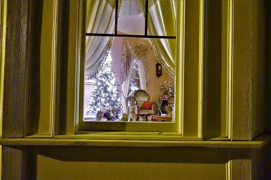 night photo of christmas room through the window