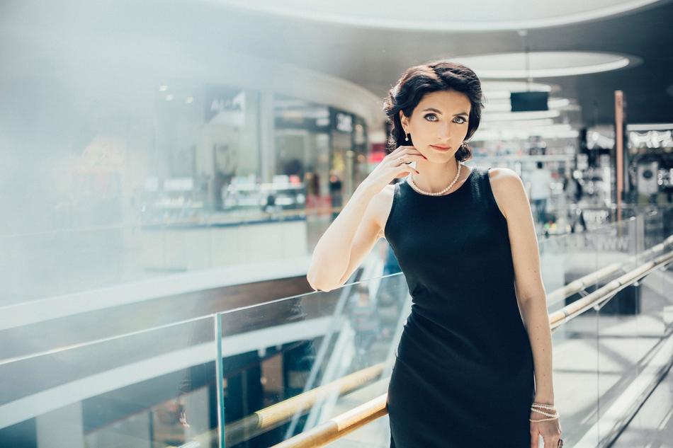 beautiful Brunette Woman posing in mall on bright background with the shops