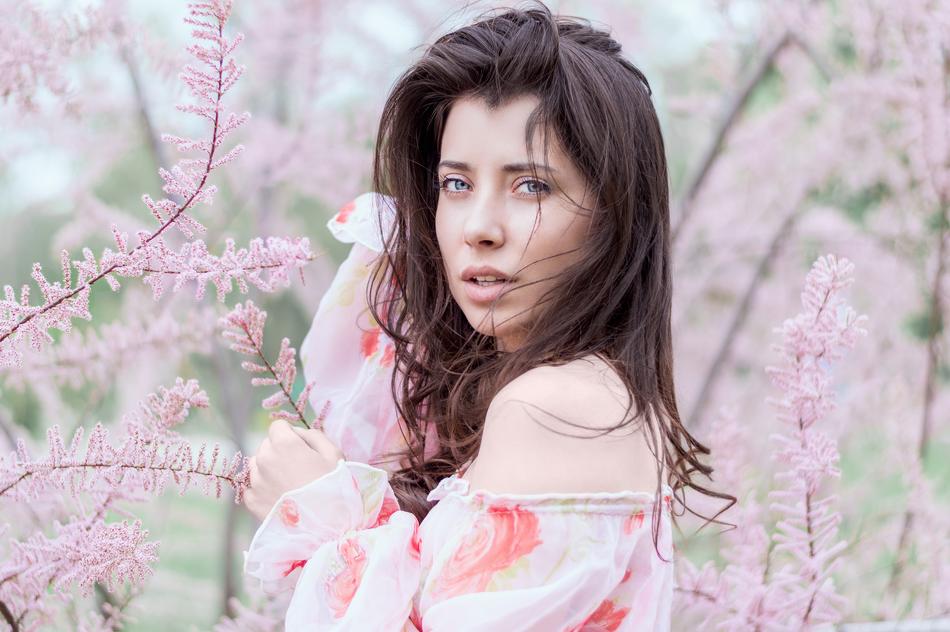 girl on the background of a blooming pink tree