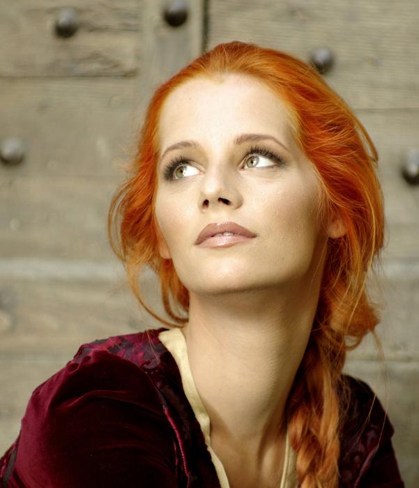 red-haired girl on the background of the castle gate