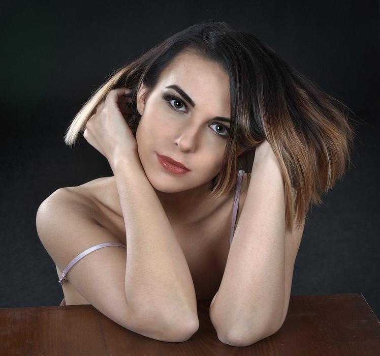 Magnificent girl posing with her hands on the table