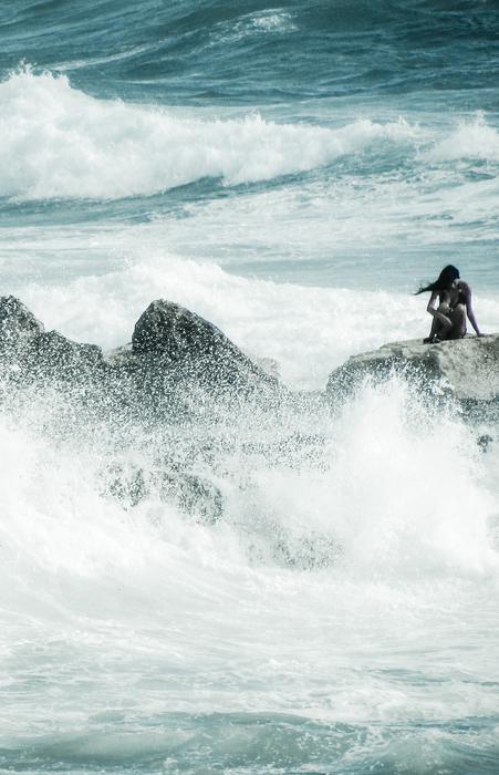 lonely woman on the sea rock