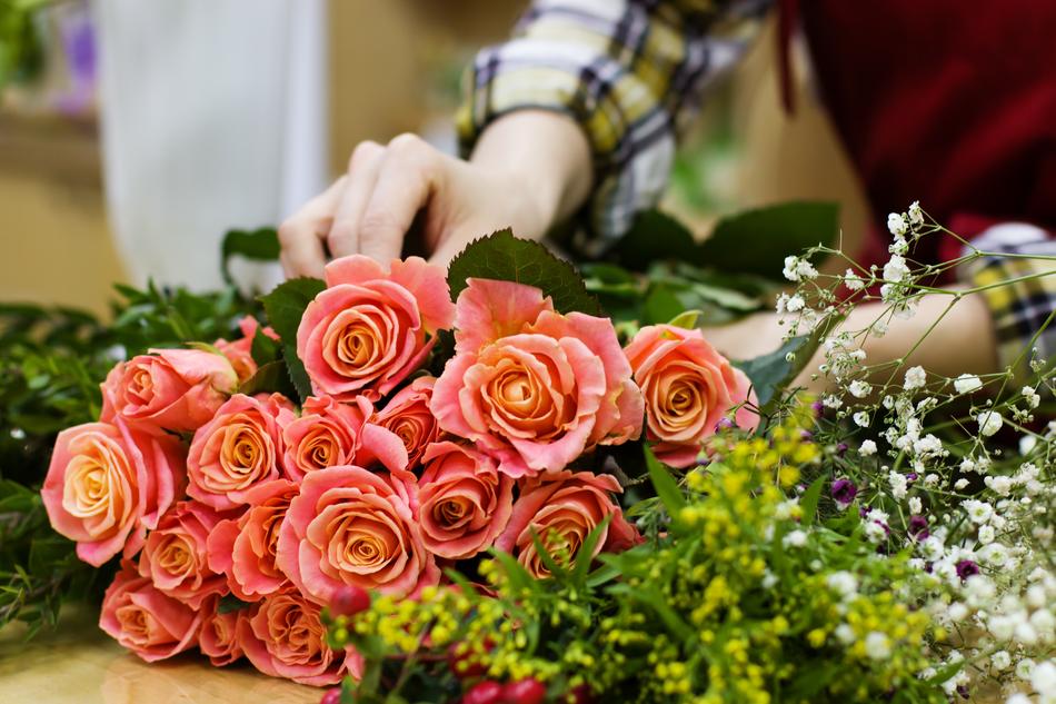 Florist makes a bouquet of pink roses