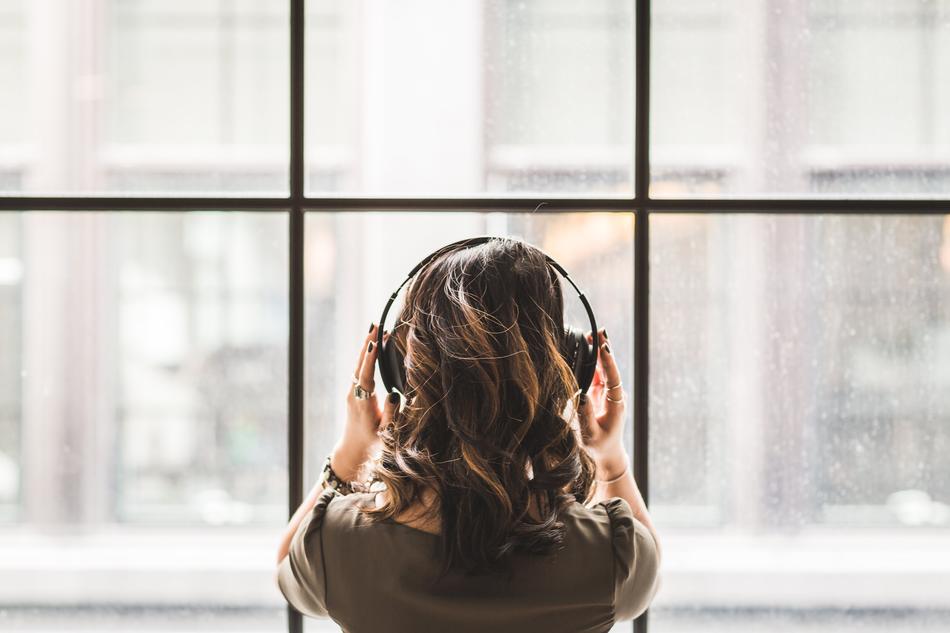 woman looking in window in headphones