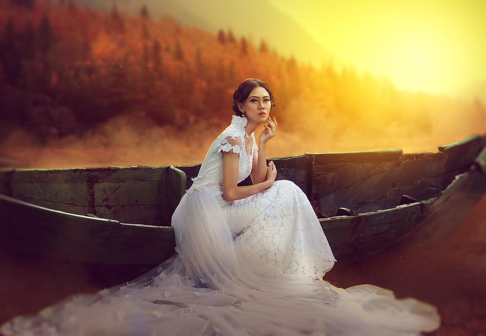 Beautiful girl sits on old boat side of , Fantasy