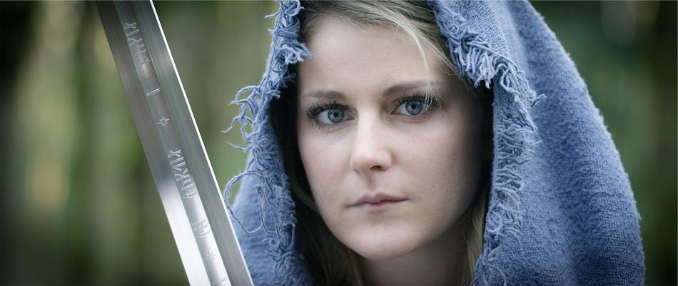 Portrait of the blonde girl covered in blue hood, with the sword