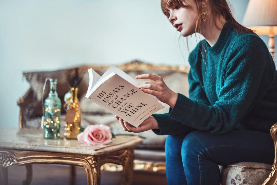 girl reading a book 101 reasons in the living room