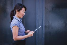 adult asian Woman with tablet in hands indoor