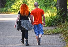 Romantic couple holding hands and walking on the road