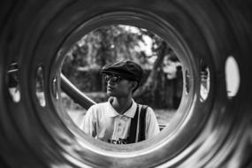monochrome photo of a fashionable guy through a pipe