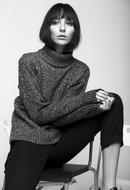 young serious woman in fashion clothing, studio portrait