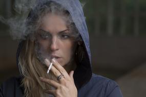 portrait of a smoking woman in hoodie