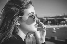 monochrome photo of a girl in sunglasses at the harbor