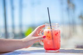 Female Hand at mug with fruit drink