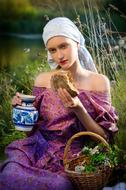 Portrait of the Slav girl in colorful clothing, with food, among the colorful plants