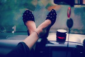 Close-up of the beautiful legs of the woman, with the black shoes, in the car