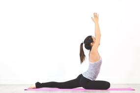 woman on pink mat in yoga pose