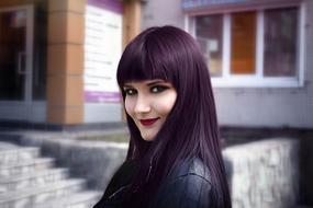 smiling dark haired Girl at building