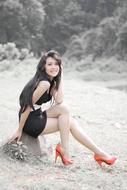 beautiful girl in red shoes on a tree stump