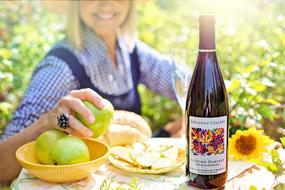 girl with fruit and a bottle of wine in the garden