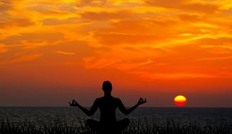silhouette of man Meditating at Sunset