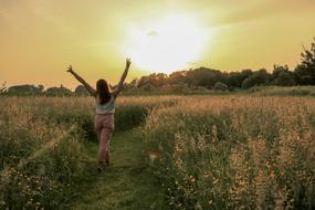 happy girl walking on Field at sunrise