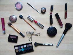 makeup brushes, shadows and lipstick on the table