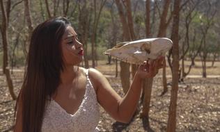 indian girl with animal skull in hand