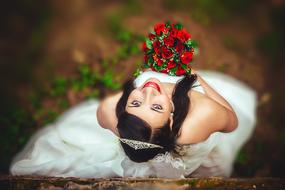 photo of a bride with a red bouquet top view