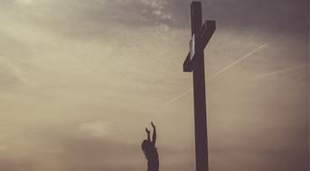 woman praying near the cross