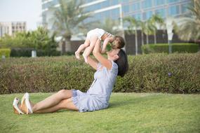 woman with little child on the green grass