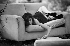 sexy Woman in high heels shoes lays on sofa