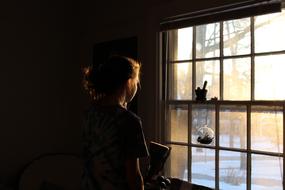 girl stands at the window