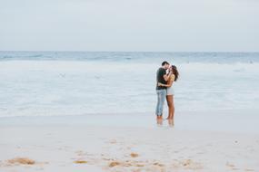 happy young couple hugging on beach at Ocean