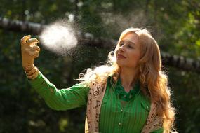 girl with white hair sprays perfume in nature