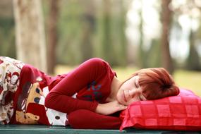 redhead girl is sleeping outdoors