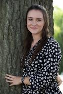 caucasian Young Girl standing at tree trunk
