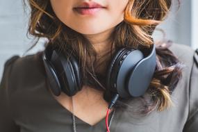 Black headphones on the neck of a woman