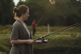 photo of a woman with a fishing rod on the lake