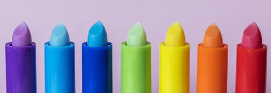 Beautiful and colorful, glossy sticks of the lip balm, at purple background