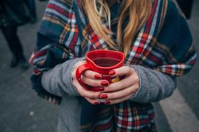 red Mug of Coffee in female hands