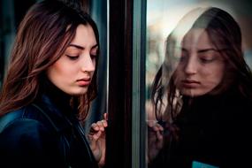 portrait of a sad young woman near the window
