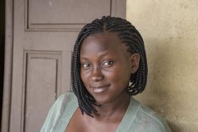 Portrait of the beautiful woman with pigtails, posing near the door