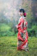 Seductive Asian girl wearing traditional clothing in garden