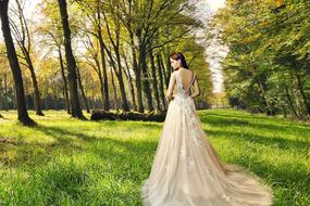 Lady in luxury Bridal gown in park