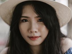 young asian woman in wide white hat