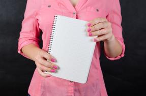 white notebook in female hands