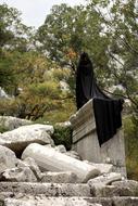 figure in black as a pose on stone ruins